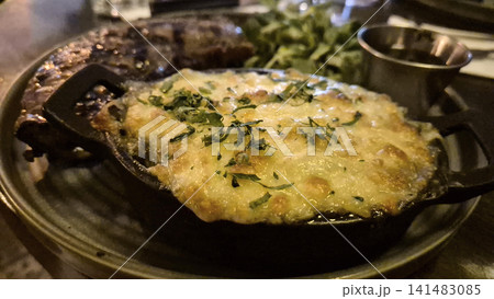 Cheesy baked dish served in sizzling skillet Cheesy baked dish served in sizzling skillet 141483085