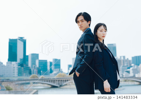 青空とビル群を背景にした男女のビジネスシーン 141483334