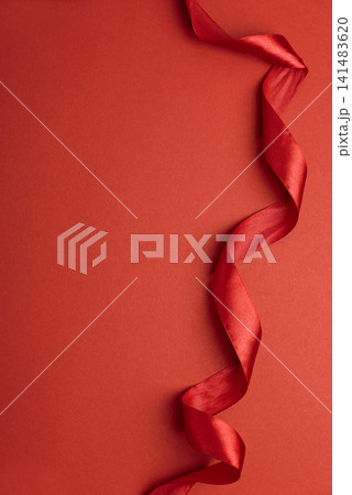 Red satin ribbon floating on red background for celebration Red satin ribbon floating on red background for celebration 141483620