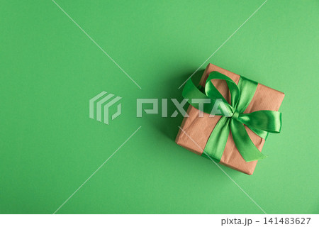 Brown paper gift box with green ribbon bow Brown paper gift box with green ribbon bow 141483627