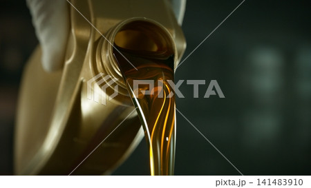 Pouring Fresh New Motor Oil into Car's Engine Pouring Fresh New Motor Oil into Car's Engine 141483910