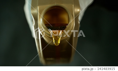 Pouring Fresh New Motor Oil into Car's Engine Pouring Fresh New Motor Oil into Car's Engine 141483915