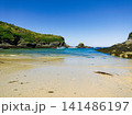 Sunny Sandy Beach Cove With Boats, Rocky Cliffs and Clear Blue Sea on a Summer Day 141486197