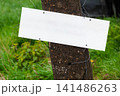 Blank White Signboard On Weathered Post In Rural Grass Field For Message Or Advertising 141486263