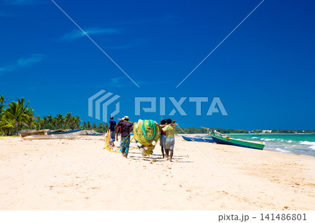 SRI LANKA - Mach 23: Local fishermen pull a fishing net from Indian Ocean on Mach 23, 2017 in Kosgoda, Sri Lanka. Fishing in Sri Lanka is the way they earn their living. 141486801