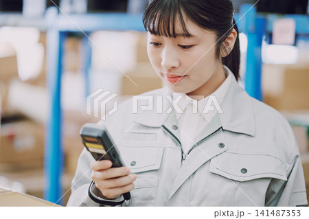 倉庫で在庫管理をする女性 倉庫で在庫管理をする女性 141487353