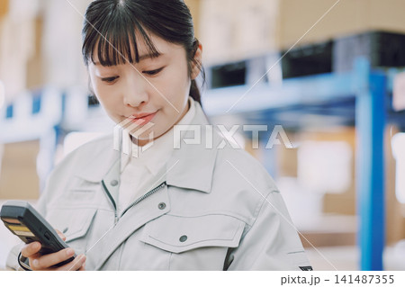 倉庫で在庫管理をする女性 倉庫で在庫管理をする女性 141487355