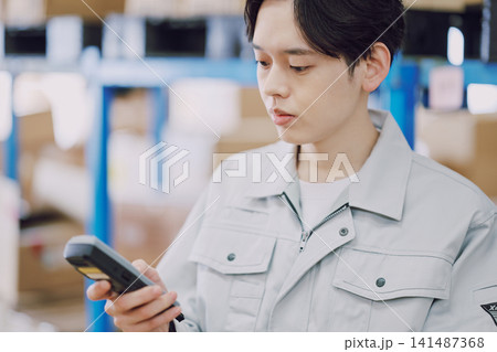 在庫管理をする作業服の男性 在庫管理をする作業服の男性 141487368