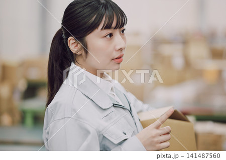 倉庫で商品チェックをする女性 倉庫で商品チェックをする女性 141487560