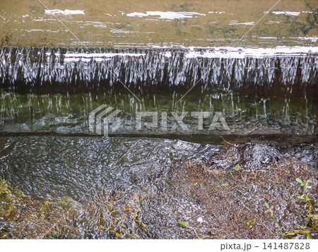 The view of the waterfall in a public park. Splashing Water, water flowing. Nature concept. 141487828