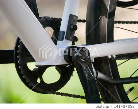 Close-up of bicycle crankset and pedal with chain drive on modern bike, cycling drivetrain detail Close-up of bicycle crankset and pedal with chain drive on modern bike, cycling drivetrain detail 141487858