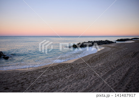 Rocky Beach Coastline At Sunrise With Calm Ocean Waves 141487917