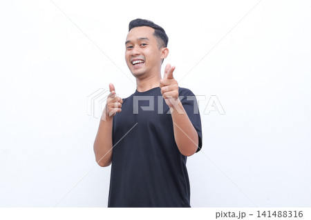 Man smiles broadly, pointing forward with both hands. He wears a simple black t-shirt, clean-cut hairstyle. Background is plain white, no distractions. His expression conveys enthusiasm, confidence Man smiles broadly, pointing forward with both hands. He wears a simple black t-shirt, clean-cut hairstyle. Background is plain white, no distractions. His expression conveys enthusiasm, confidence 141488316