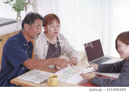 老後の住まいについて相談するシニア夫婦 141488388