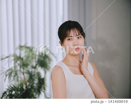 肌の潤いを実感する若い女性 141488659