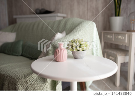 White round table with pink vase in cozy bright living room, furniture catalog, home decor marketing White round table with pink vase in cozy bright living room, furniture catalog, home decor marketing 141488840