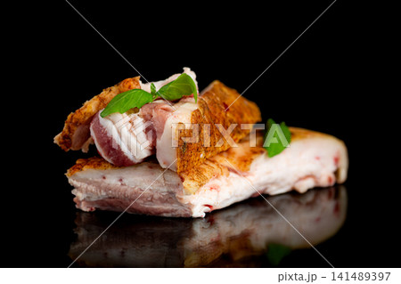 Seasoned pork lard with aromatic basil on glossy black background 141489397