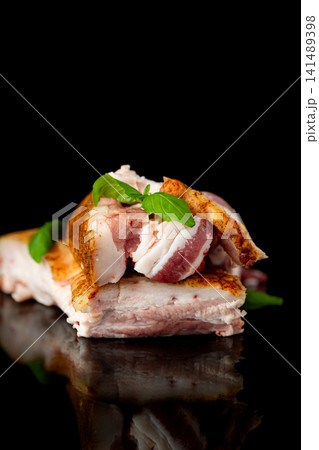 Homemade cured pork fat with green basil on elegant black background Homemade cured pork fat with green basil on elegant black background 141489398
