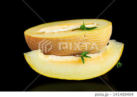 Organic cantaloupe melon slice with green basil on dark reflective surface 141489404