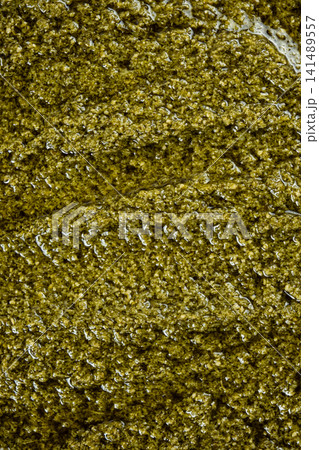 Close-up texture of fresh green pesto sauce with olive oil Close-up texture of fresh green pesto sauce with olive oil 141489557