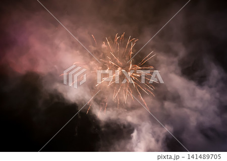 Golden Fireworks Bursting in Smoky Night Sky Celebration Golden Fireworks Bursting in Smoky Night Sky Celebration 141489705