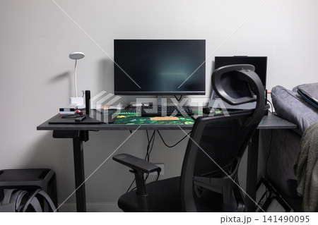 Modern computer workstation with monitor, laptop, office chair and desk accessories arranged in a home office, creating a practical workspace for study, work and daily computing tasks 141490095
