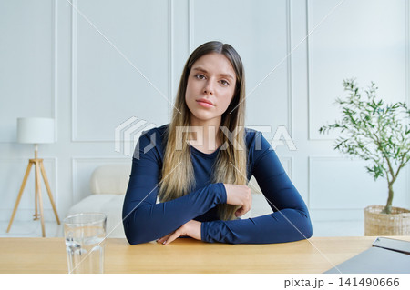 Concerned young woman looking directly at camera gesturing frustration during video call Concerned young woman looking directly at camera gesturing frustration during video call 141490666