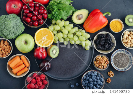Healthy antioxidant rich foods flat lay on dark background with copy space 141490780