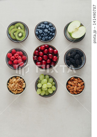 Healthy antioxidant rich fruits, berries and nuts on light background 141490787