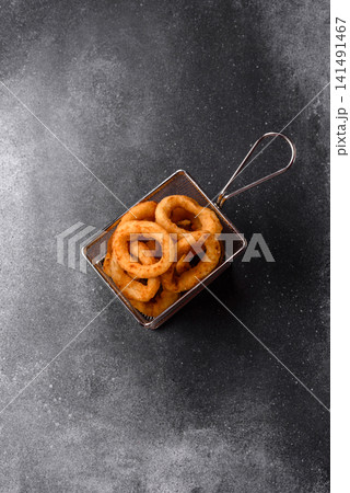 Deep fried breaded onion or squid rings, crispy fast food snacks. Fried onion or squid rings Deep fried breaded onion or squid rings, crispy fast food snacks. Fried onion or squid rings 141491467