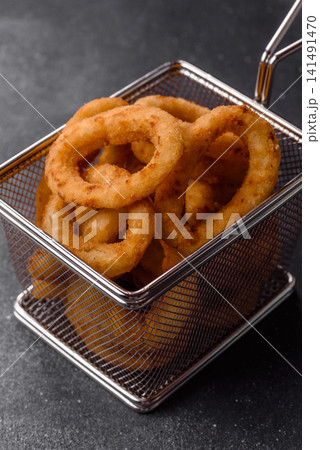 Deep fried breaded onion or squid rings, crispy fast food snacks. Fried onion or squid rings Deep fried breaded onion or squid rings, crispy fast food snacks. Fried onion or squid rings 141491470