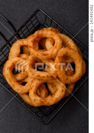 Deep fried breaded onion or squid rings, crispy fast food snacks. Fried onion or squid rings Deep fried breaded onion or squid rings, crispy fast food snacks. Fried onion or squid rings 141491482