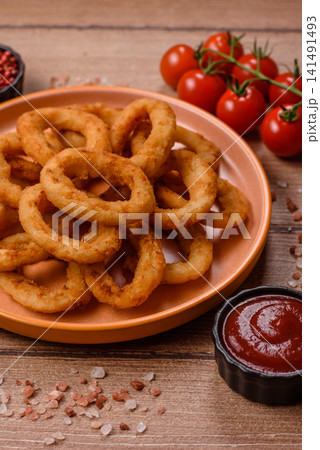 Deep fried breaded onion or squid rings, crispy fast food snacks. Fried onion or squid rings Deep fried breaded onion or squid rings, crispy fast food snacks. Fried onion or squid rings 141491493