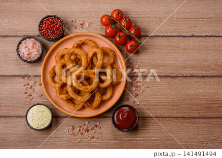 Deep fried breaded onion or squid rings, crispy fast food snacks. Fried onion or squid rings Deep fried breaded onion or squid rings, crispy fast food snacks. Fried onion or squid rings 141491494