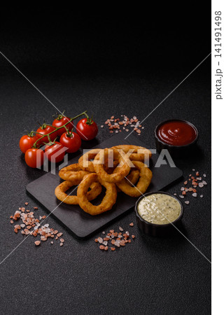 Deep fried breaded onion or squid rings, crispy fast food snacks. Fried onion or squid rings Deep fried breaded onion or squid rings, crispy fast food snacks. Fried onion or squid rings 141491498