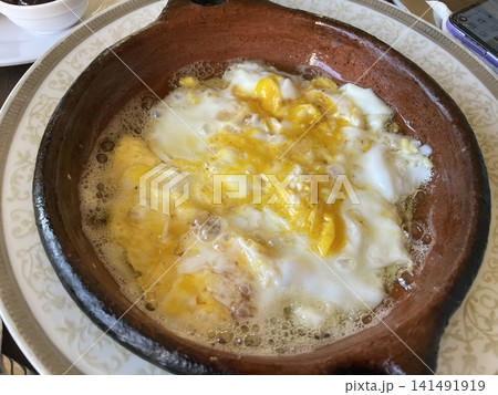 Traditional Moroccan Breakfast Eggs Cooked in Clay Pot Skillet Traditional Moroccan Breakfast Eggs Cooked in Clay Pot Skillet 141491919