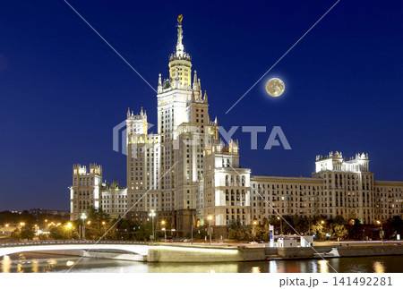 Kotelnicheskaya Embankment Building at night with the super moon, Moscow, Russia-- is one of seven stalinist skyscrapers laid down in September, 1947 and completed in 1952. Kotelnicheskaya Embankment Building at night with the super moon, Moscow, Russia-- is one of seven stalinist skyscrapers laid down in September, 1947 and completed in 1952. 141492281
