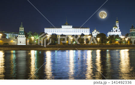 Night view of the Moskva River and Kremlin, Russia, Moscow (most popular view). Against the background of a beautiful sky with clouds, with the moon Night view of the Moskva River and Kremlin, Russia, Moscow (most popular view). Against the background of a beautiful sky with clouds, with the moon 141492336