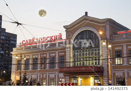 Savelovsky railway station (Savyolovsky, Savyolovskiy, Savyolovsky or Savelovskiy-- written in Russian) with the super moon -- is one of the nine main railway stations in Moscow, Russia (at night) 141492373