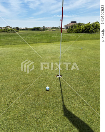 Golf Ball Close to the Hole on a Sunny Day at the Course Golf Ball Close to the Hole on a Sunny Day at the Course 141492622