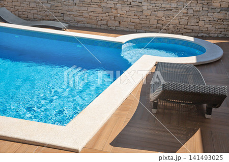 Modern swimming pool edge with sun loungers. Modern swimming pool edge with sun loungers. 141493025