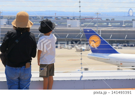 離陸する飛行機を眺める親子　羽田空港の展望デッキ 141493391