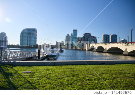 Stone Arch Bridge Over Waterway With City Skyline Backdrop 141493670