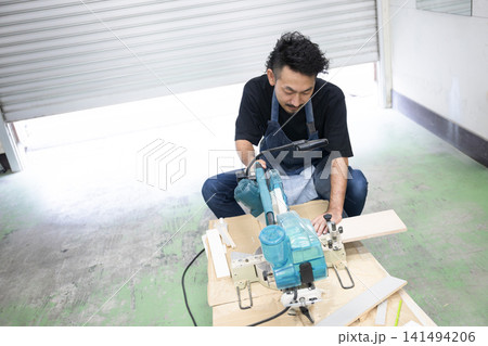 DIY・木工でスライド丸ノコを使って木材加工する男性職人 電動工具によるの家具製作の日曜大工など DIY・木工でスライド丸ノコを使って木材加工する男性職人 電動工具によるの家具製作の日曜大工など 141494206
