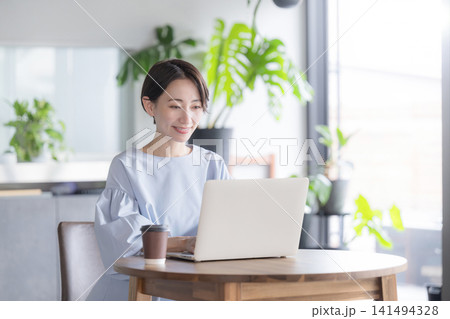 観葉植物のあるオシャレなオフィスでノートパソコンで仕事をする日本人女性 オフィスビジネスシーン 観葉植物のあるオシャレなオフィスでノートパソコンで仕事をする日本人女性 オフィスビジネスシーン 141494328