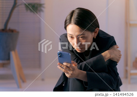 ボーッとスマホを見る女性 ボーッとスマホを見る女性 141494526