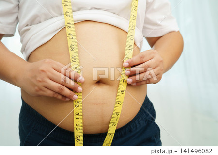 Asian woman with fat belly big size overweight and obesity with measure tape. Asian woman with fat belly big size overweight and obesity with measure tape. 141496082