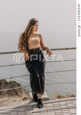 Woman sea viewpoint leaning on railing overlooking misty ocean during peaceful morning with copy space Woman sea viewpoint leaning on railing overlooking misty ocean during peaceful morning with copy space 141499344