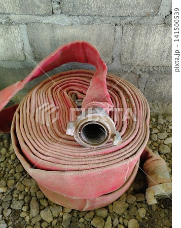 a roll of fire hose lying on the ground 141500539