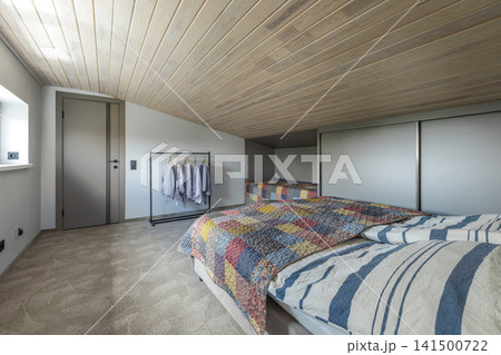 Bedroom Interior with Beds, Wardrobe, and Clothing Rack 141500722